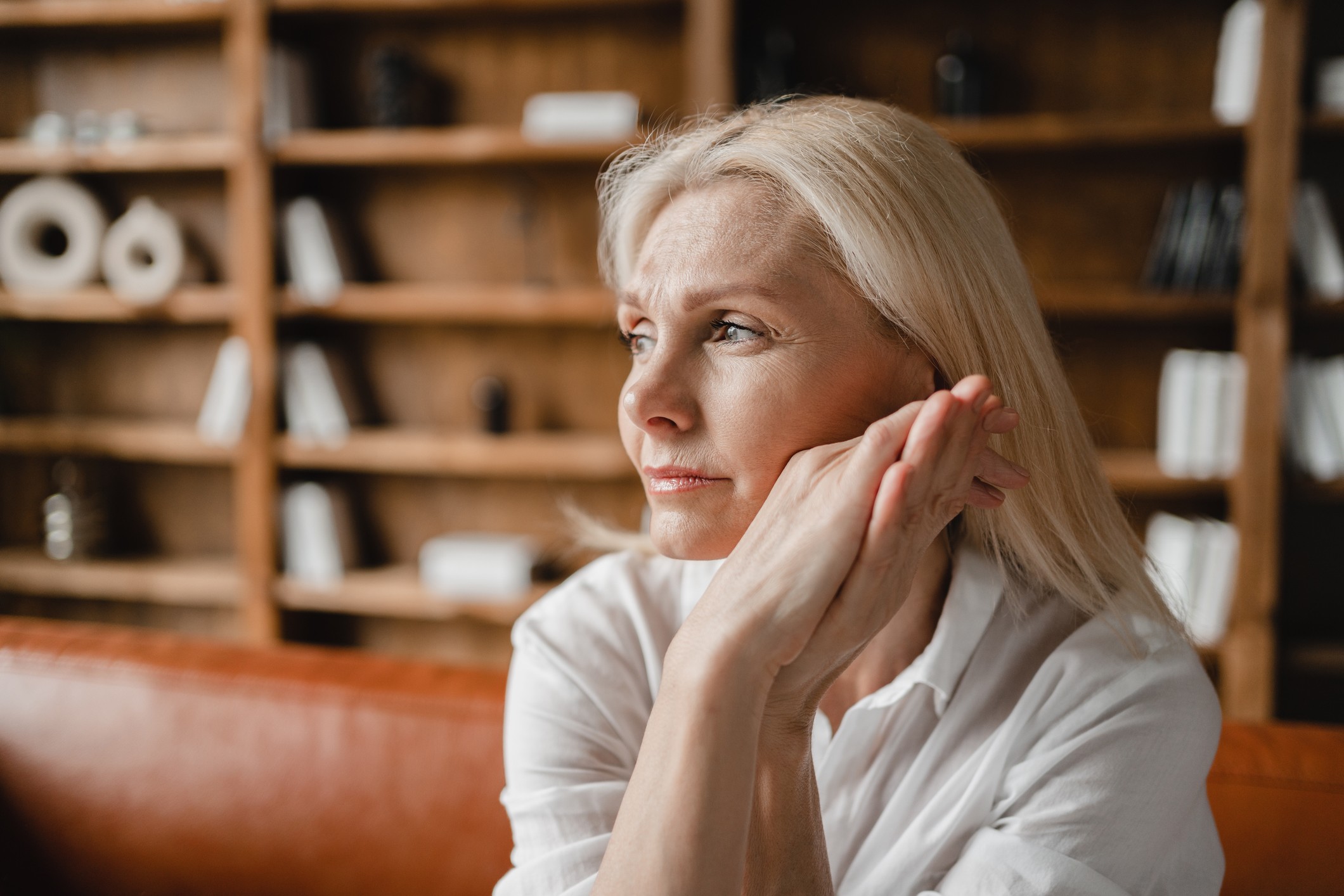 Stressed sad tired exhausted caucasian middle-aged mature businesswoman freelancer relaxing on the couch sofa, thinking about family marriage work problems at work office