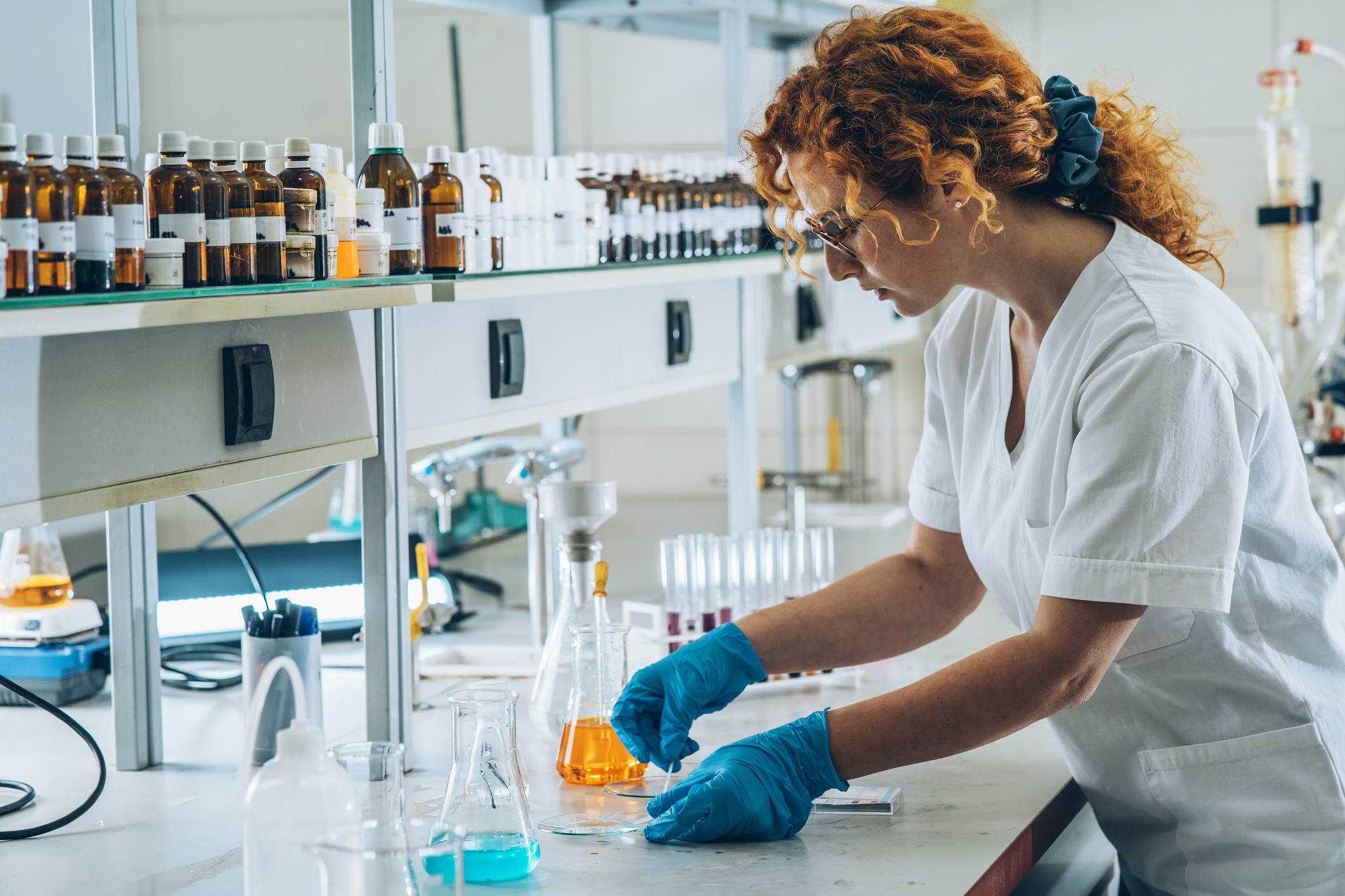 Red hair female chemistry scientist and student doing experiment in the lab.