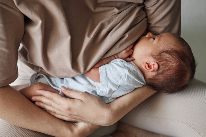 Mother breastfeeding home. Nursing mother. Breast milk benefits. Unrecognizable woman young mother and son breastfeeding baby